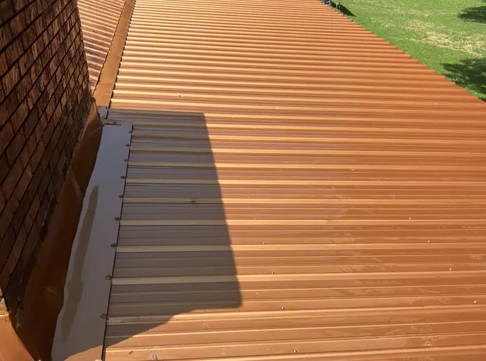 Metal roof restored to a clean terracotta color after a soft wash
