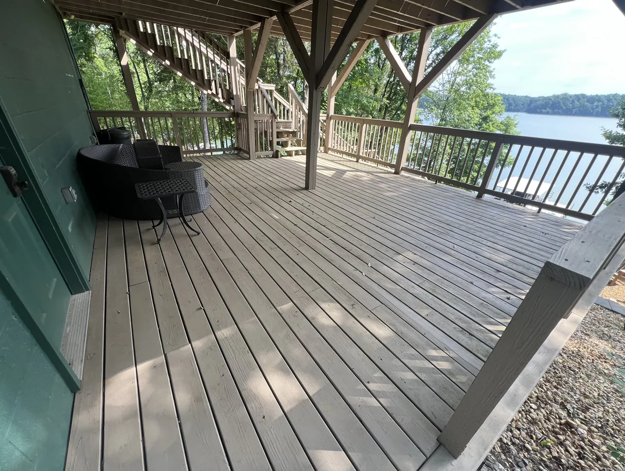 Covered wood deck cleaned back to bare board, looking out over the lake