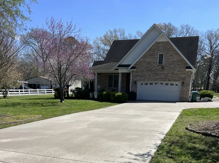 Brick home with its concrete driveway cleaned front to back