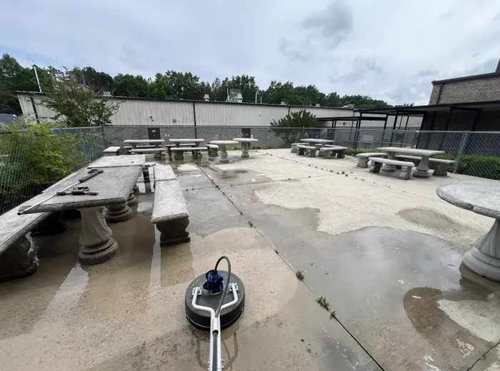 Surface cleaner at work on the stained concrete of a commercial picnic area