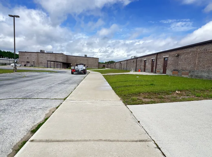 Concrete walkway cleaned along a brick commercial building