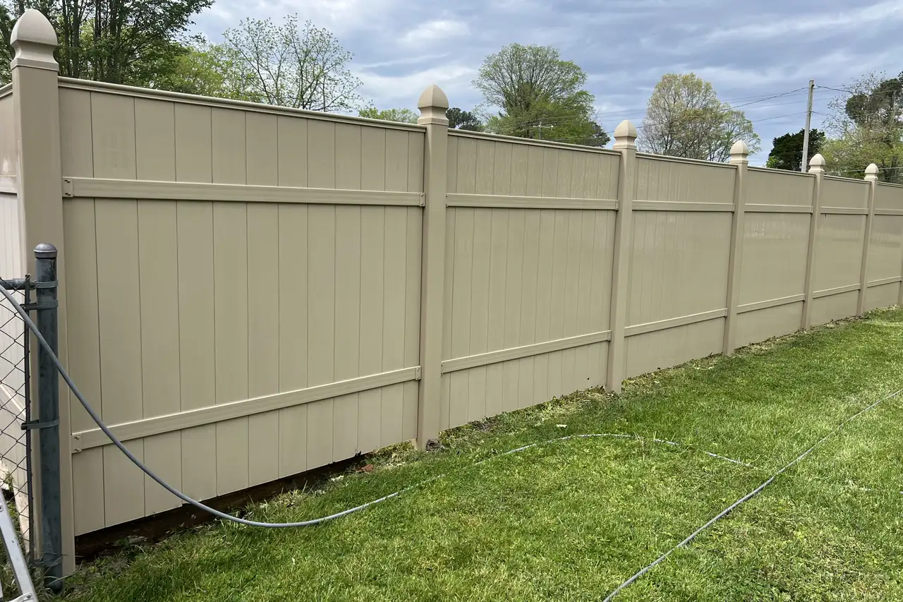 Long vinyl privacy fence cleaned along a back lawn